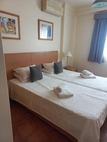 a bedroom with a large white bed with towels on it at Altura Sunshine in Altura