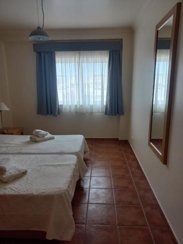 a room with two beds and a window with blue curtains at Altura Sunshine in Altura