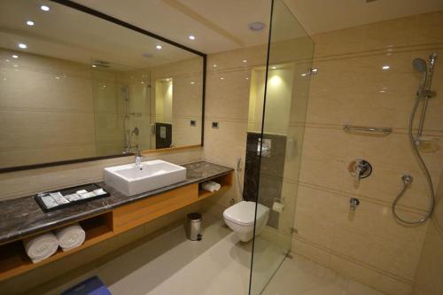 a bathroom with a sink and a toilet and a shower at Pearltree Hotels And Resorts in Purulia