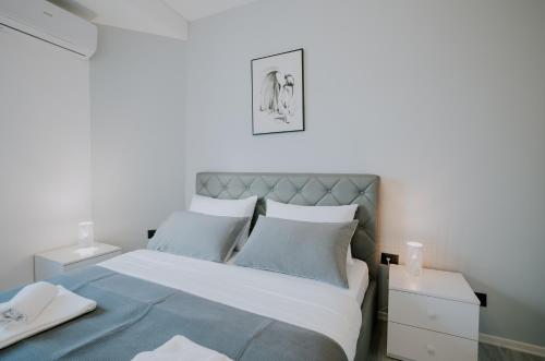 a bedroom with a bed with blue and white at Elrea Living 2 Central 1BR with Dajti & Skyline View in Tirana