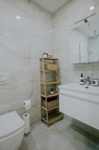 a white bathroom with a toilet and a sink at Elrea Living 2 Central 1BR with Dajti & Skyline View in Tirana