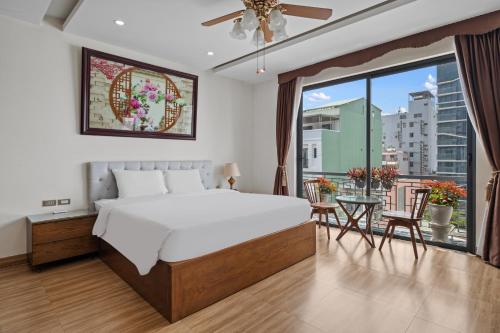 a bedroom with a large bed and a balcony at AVA Hotel & Apartment in Danang