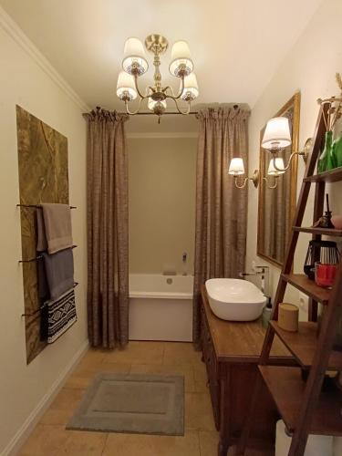 a bathroom with a chandelier and a sink at Pievų Tako kiemelis in Klaipėda