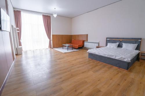 a bedroom with a bed and a wooden floor at Nura Hotel in Shymkent