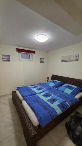 a bedroom with a bed with a blue comforter at B&M Apartment in Zierenberg