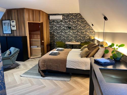 a bedroom with a king sized bed and a bathroom at Het Pauwtje in Zoutelande