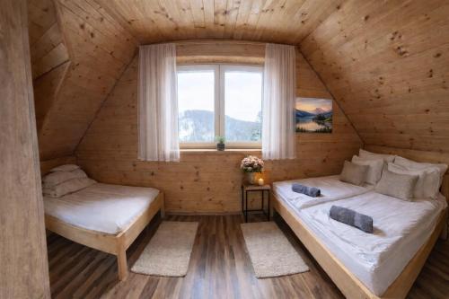 a bedroom in a log cabin with a bed and a window at UROCZYSKO-POLAŃCZYK Prywatne Jacuzzi i Sauna w cenie !!! in Polańczyk