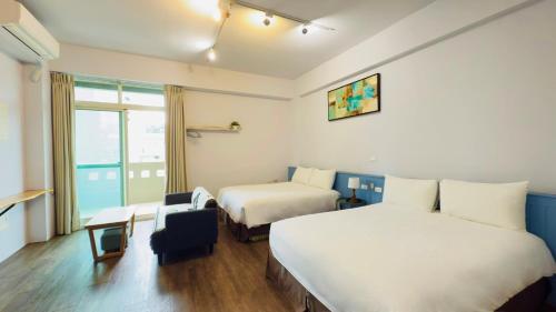 a hotel room with two beds and a window at 小逗民宿 in Taitung City