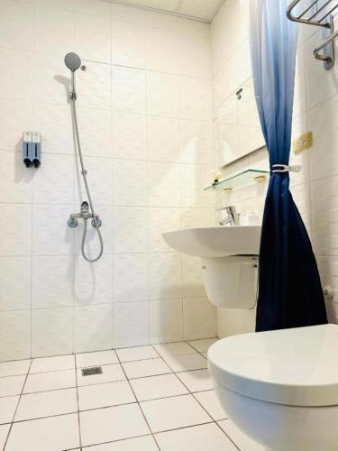 a bathroom with a shower and a toilet and a sink at 小逗民宿 in Taitung City