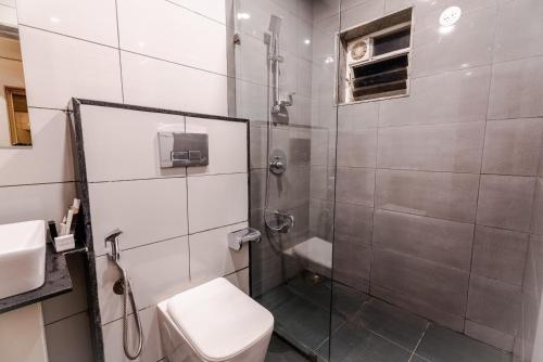 a bathroom with a shower and a toilet and a sink at Cana Boutique Stay in Porvorim