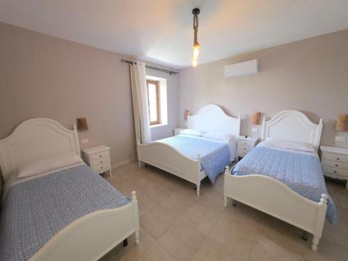 a bedroom with two beds and a window at Bed&Wine Terrae Tiferni in Gioia Sannitica