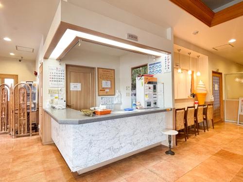 a kitchen with a counter with a large mirror at Hotel Livemax Tagajo in Tagajo