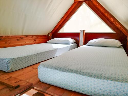 two twin beds in a room with a window at Club del Sole Roseto degli Abruzzi Easy Camping Village in Roseto degli Abruzzi