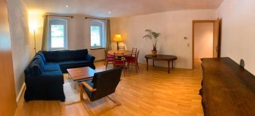 a living room with a blue couch and a table at Statesman Suite in Königstein an der Elbe
