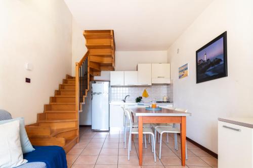 a kitchen and living room with a table and a staircase at Mamì Altanea Village in Duna Verde