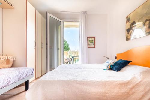 a bedroom with a large bed and a balcony at Mamì Altanea Village in Duna Verde