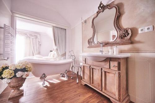 a bathroom with a tub and a sink and a mirror at Dworek Bukowy Park in Szczecin