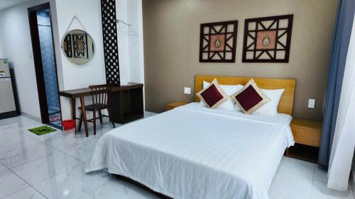 a bedroom with a large white bed and a table at 60 Inn Saigon in Ho Chi Minh City