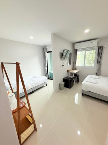 a bedroom with two beds and a desk in it at Dana Residence in Ko Yao Noi