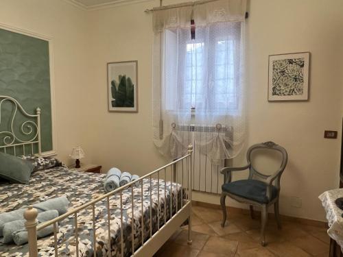 a bedroom with a bed and a chair and a window at Rhome country lodge in La Massimina-Casal Lumbroso