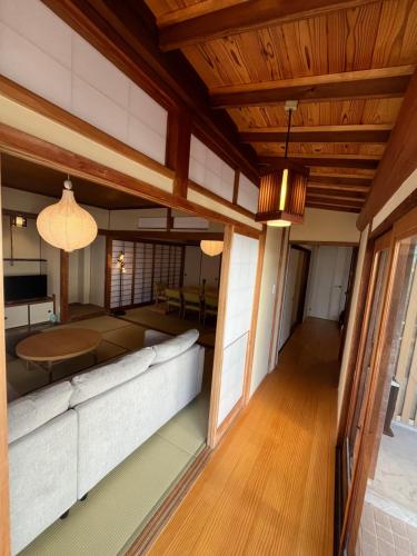 a living room with a couch and a table at 伊都伎-Itsuki- 宮島口の貸切一軒家 世界遺産宮島へ渡る港まで徒歩圏内 最大16名 in Hatsukaichi