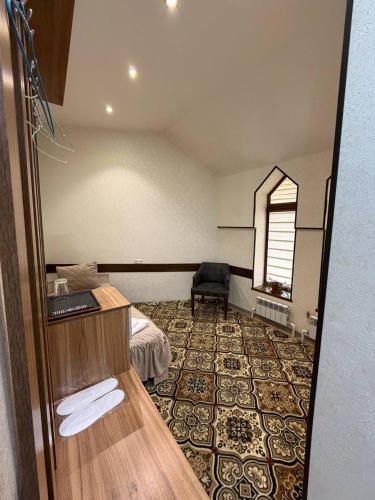 a hotel room with a bed and a chair at Shamshod Mountain Resort in Yangiobod