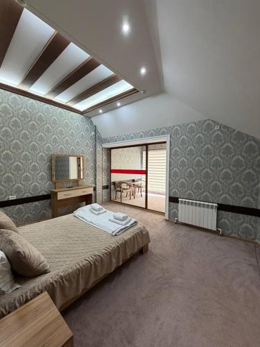a bedroom with a bed and a table and a window at Shamshod Mountain Resort in Yangiobod