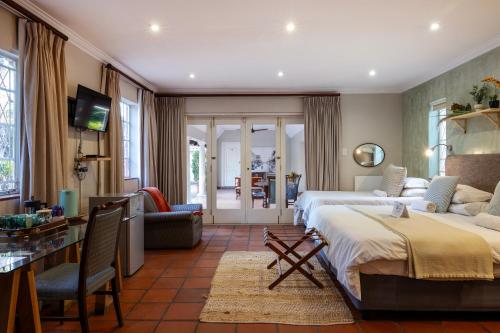 a bedroom with two beds and a living room at Brooklyn Manor in Pretoria