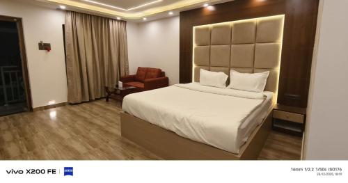 a hotel room with a bed and a chair at White Coastal Beach Resort in Mandarmoni