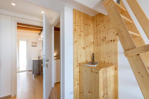 a room with a wooden wall and a staircase at Aghèl Luxury Room in Recanati