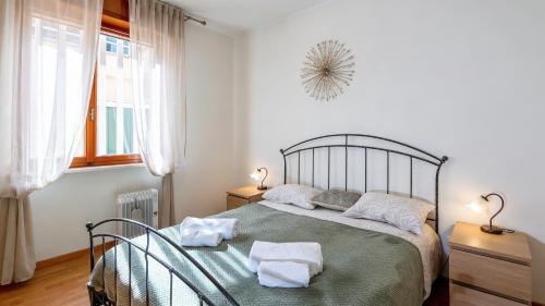 a bedroom with a bed with two towels on it at Lake Apartment by GardaDoma in Brenzone sul Garda