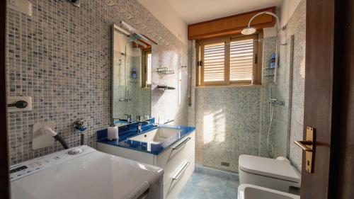 a bathroom with a sink and a toilet and a shower at Lake Apartment by GardaDoma in Brenzone sul Garda