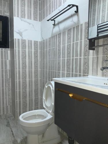 a bathroom with a toilet and a sink at La MAISON SEONE SILVER in Abidjan