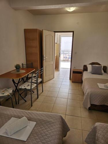 a hotel room with two beds and a table and a door at Apartmani Vista Čanj in Čanj