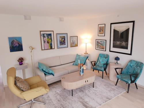 a living room with a couch and two chairs at Karlotte's apartment in Ballstad