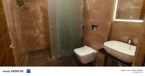 a bathroom with a toilet and a sink at White Coastal Beach Resort in Mandarmoni