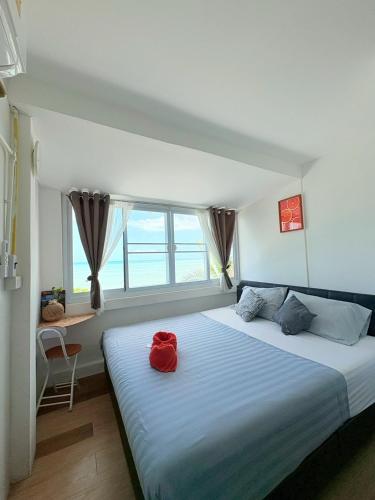a bedroom with a large bed with red pillows on it at The Dreamcatcher Hostel Nathon SamuiSunset in Nathon