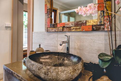 a bathroom with a large stone sink on a counter at Albany Bali Style Accommodation in Albany