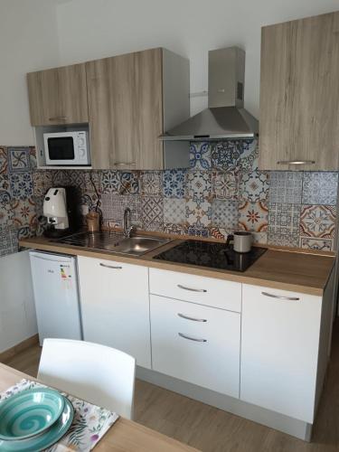 a kitchen with white cabinets and a sink at La casetta Bianca in Modica