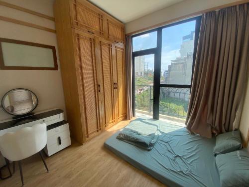 a bedroom with a bed and a large window at Lexe Palace Tam Dao in Tam Ðảo