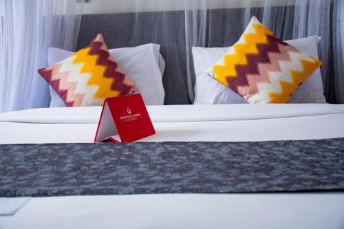 a hotel room with two beds with colorful pillows at Distinction Gardens in Siaya