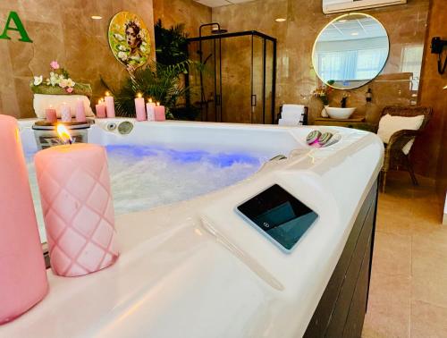 a bathroom with a tub with candles in it at Plaza Hotel Gyula in Gyula