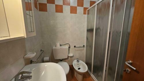 a bathroom with a toilet and a sink and a shower at Familiar apartment with terrace in Rosolina in Rosolina Mare