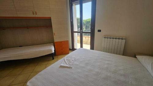 a bedroom with two beds and a large window at Familiar apartment with terrace in Rosolina in Rosolina Mare
