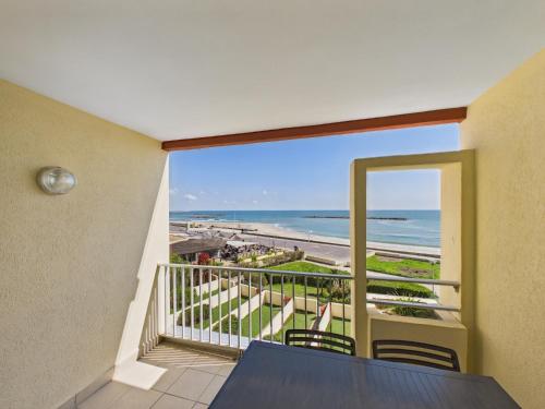 a balcony with a table and chairs and a view of the beach at Résidence de Tourisme l'Albatros in Palavas-les-Flots