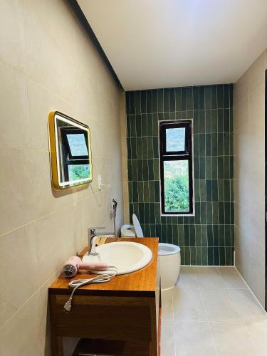 a bathroom with a sink and a toilet and a window at Núp Gió Cottages in Ấp Mỹ Hải