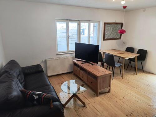 a living room with a couch and a table with a television at Ferienwohnung Naturglück in Sellrain