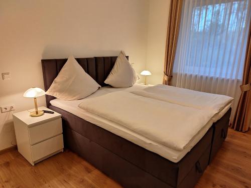 a bedroom with a large bed with white sheets and pillows at Ferienhof Große Drieling in Greven