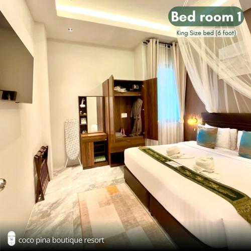 a bedroom with a large bed and a dressing room at Coco Pina in Prachuap Khiri Khan
