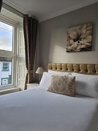 a bedroom with a large white bed with a window at Brogans Bar & Hotel in Trim
